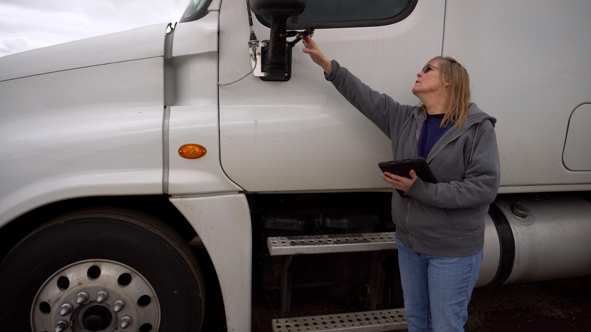Semi Truck being inspected by female truck driver